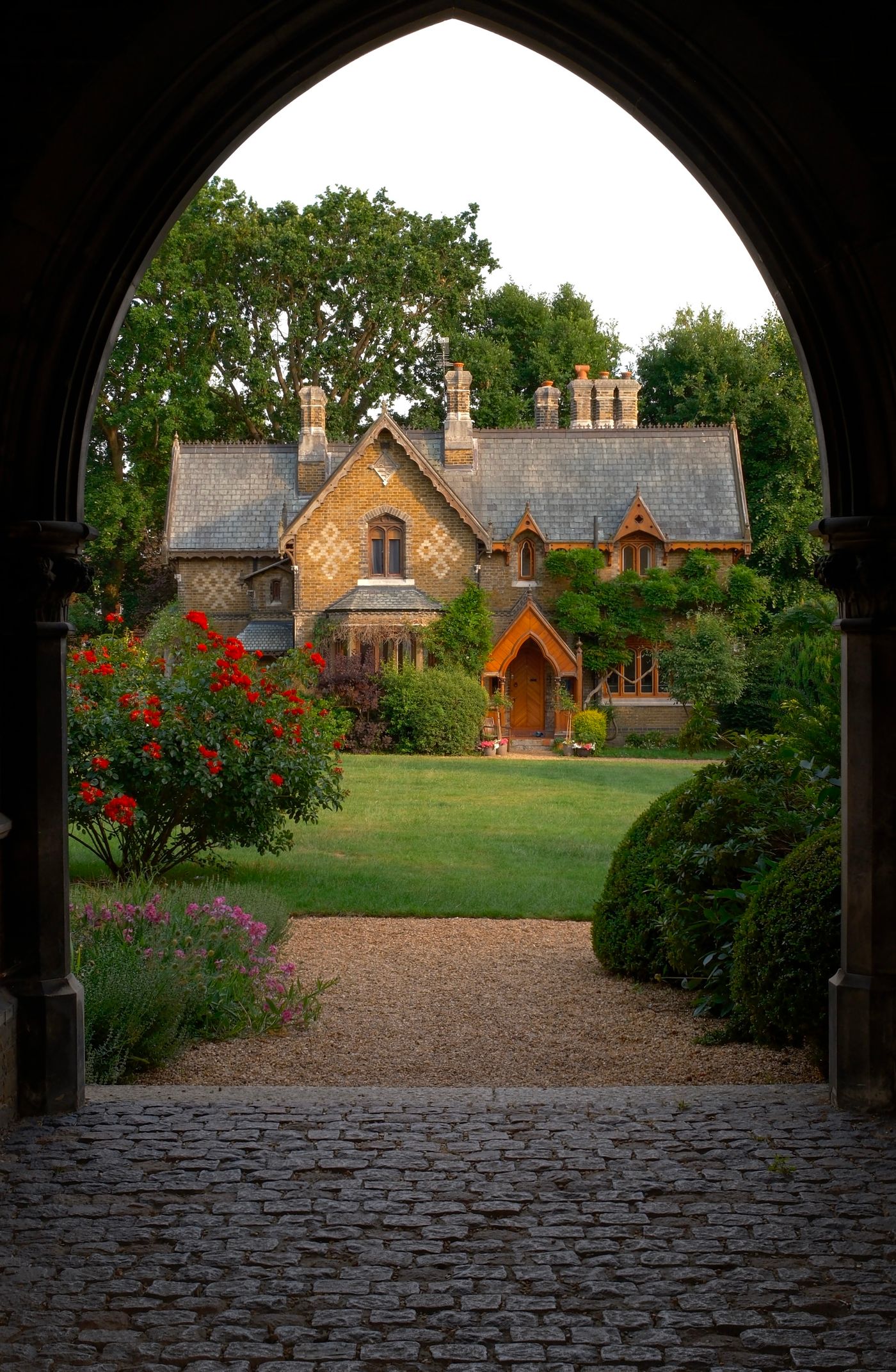 A country house seen through an old stone archway